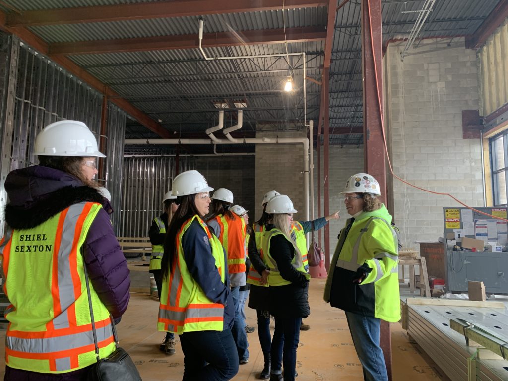 Women construction workers conversing inside building