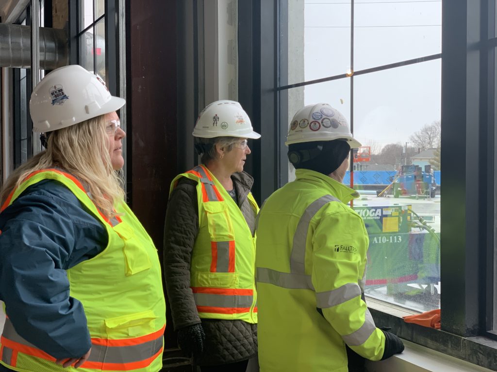 three construction workers looking out window